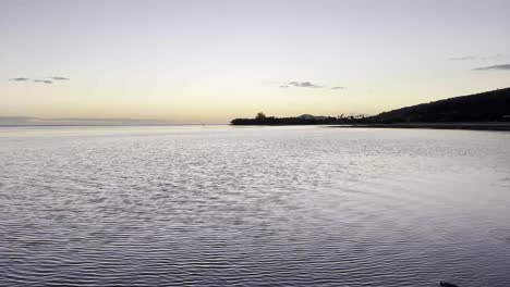 Las-Tranquilas-Aguas-De-Oahu-Reflejan-Los-Suaves-Tonos-Pastel-Del-Sol-Poniente.