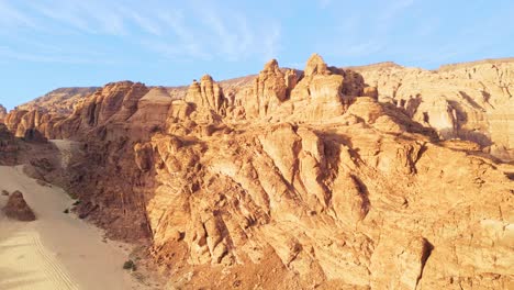 Vista-Aérea-De-Drones-De-Impresionantes-Vistas-De-Majestuosos-Acantilados-Del-Desierto-Bajo-Un-Cielo-Azul-Claro-Cerca-De-Al-ula-En-Arabia-Saudita