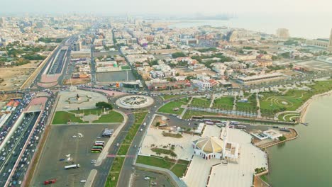 Vista-Aérea-Del-Bullicioso-Paisaje-Urbano-Y-El-Paseo-Marítimo-De-Jeddah,-Que-Muestra-La-Arquitectura-Moderna,-Las-Calles-Vibrantes-Y-La-Belleza-Costera.