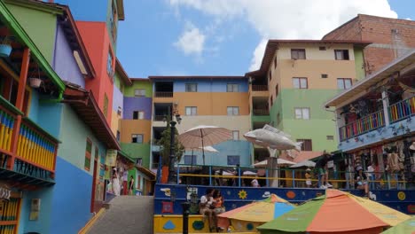 Colorful-Buildings-and-People-on-Plazoleta-de-Los-Zocalos,-Tourist-Attraction-of-Guatape,-Colombia