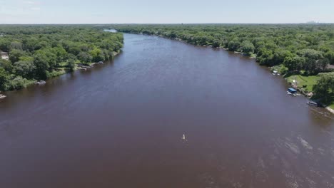 High-angle-aerial-view-of-kayaker-paddling-Mississippi-river-in-Chaska,-Minnesota-in-USA