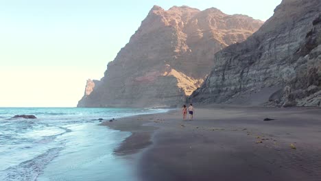 Idyllic-scene-of-two-people-at-unspoiled-virgin-beach-in-Gran-Canaria,-Spain-during-summer-time-on-vacations