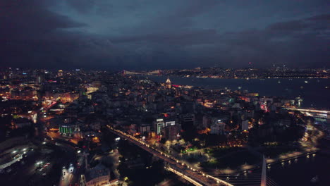 Amplia-Toma-Aérea-De-Beyoglu,-Ciudad-De-Estambul-Por-La-Noche,-Impresionantes-Luces-Y-Nubes-En-El-Cielo,-Cámara-Lenta-Y-Espacio-Para-Copiar