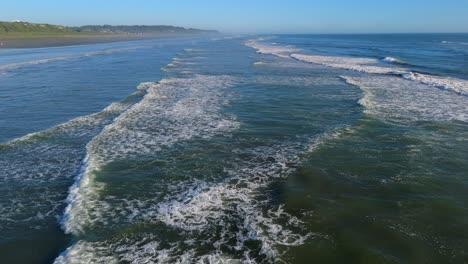 Toma-Aérea-Sobre-Las-Olas-Del-Océano-En-El-Océano-Pacífico-Con-Playa-En-Un-Día-De-Cielo-Azul