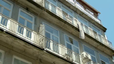 Panning-over-some-windows-and-balconies-along-a-building-in-Porto,-Portugal