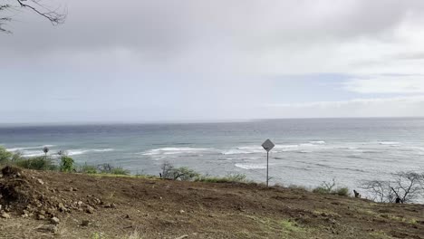 Una-Vista-Panorámica-Del-Horizonte-Costero-Con-Suaves-Olas-Que-Llegan-A-La-Orilla,-Bajo-Un-Cielo-Parcialmente-Nublado