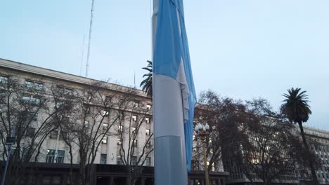 Lowering-the-flag-of-Argentina-down-a-pole-in-central-plaza-landmark-close-up