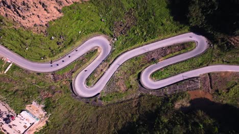 This-aerial-footage-captures-the-winding-roads-of-Ha-Giang-in-Vietnam,-as-motorcycles-navigate-the-and-challenging-terrain