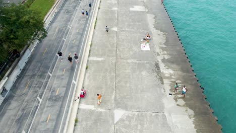 Luftaufnahme-Einer-Ruhigen-Seepromenade-Mit-Fußgängern,-Die-Einen-Gemütlichen-Tag-In-Chicago-Genießen