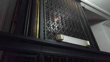 Old-vintage-caged-elevator-goes-down-in-a-french-style-apartment-indoors