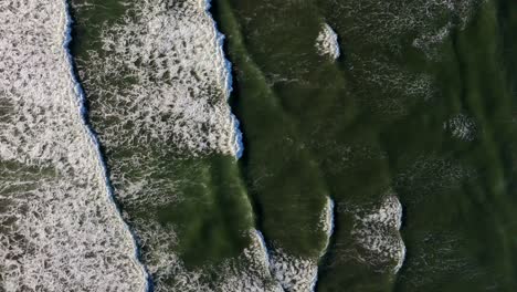 Scenic-aerial-forward-shot-looking-down-at-waves-in-the-Pacific-Ocean-at-Ocean-Shores,-Washington-State