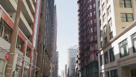 Slow-motion-shot-looking-down-the-street-in-downtown-St,-Louis-with-large-buildings-lining-both-sides