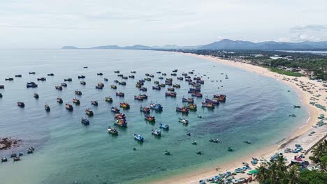 Tanzende-Fischerboote-Vibrieren-Im-Zeitraffer-Im-Aquamarinblauen-Wasser-Eines-Abgelegenen-Weißen-Sandstrands-In-Der-Küstenbucht-Eines-Fischerdorfs-In-Vietnam