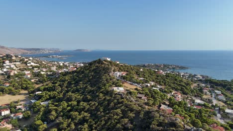 Circle-shot-of-a-hill-at-a-seaside-area-in-Attica-region-|-Blue-beach-village-at-Lagonisi