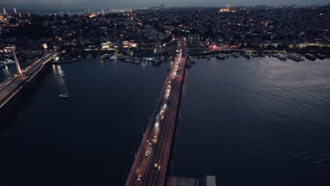 Blue-hour-night-shot-of-two-bridges-over-the-river-of-Istanbul-city-with-traffic,-copy-space-and-slow-motion,-pan-shot