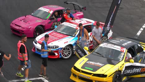 Exposición-De-Autos-De-Carrera-En-Las-Pistas-De-Carreras-Toma-Más-Cercana-Y-Panorámica