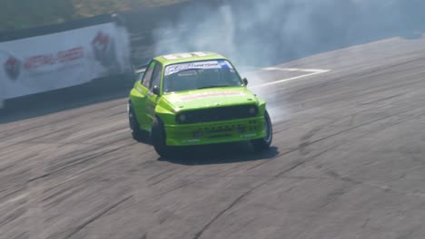 Green-BMW-race-car-drifting-burning-tires-with-lots-of-smoke