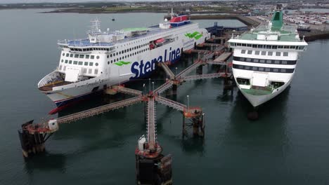 Irish-Ferries-and-Stena-line-docked-passenger-ships-aerial-view-rising-over-Holyhead-harbour-port