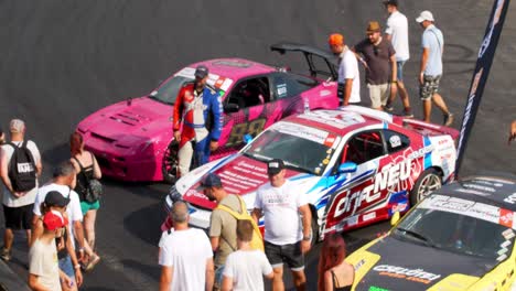 Race-cars-exhibition-on-the-racing-tracks,-people-checking-on-the-race-cars