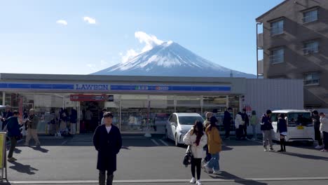 Tourist-posing-in-front-of-the-Lawson-Supermarket-in-front-of-Mount-Mt-Fuji-in-Kawaguchiko-Japan