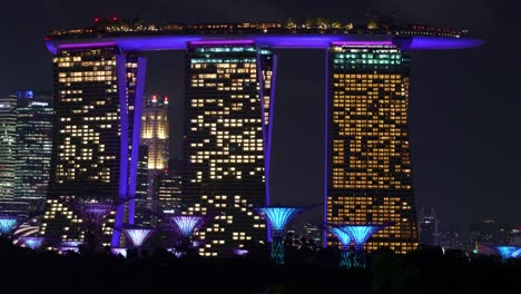 Wahrzeichen-Von-Singapur,-Das-Das-Beleuchtete-Marina-Bay-Sands-Resort-Hotel-Und-Den-Supertree-Grove-In-Den-Gärten-An-Der-Bucht-Bei-Nacht-Einfängt