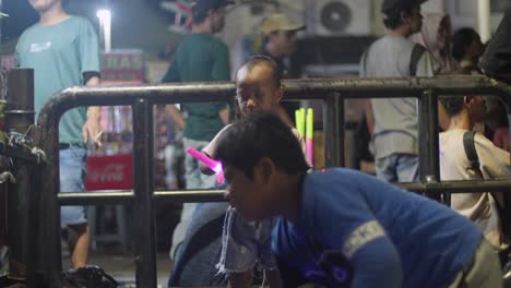 Indonesische-Kinder-Spielen-Mit-Spielzeug-Lichtschwertern-Auf-Taman-Fatahillah,-Einem-Touristenort