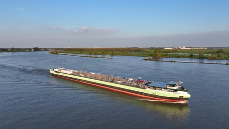 Aerial-Drone-View-of-Cargo-Ship-Navigating-the-Waterway-in-Barendrecht,-Netherlands---Morning-Maritime-Scene