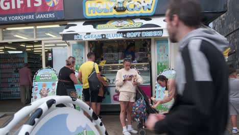 Imágenes-De-Clientes-Comprando-Helado-En-Scarborough,-En-Un-Fin-De-Semana-Ajetreado-Con-Familias-Disfrutando-Del-Balneario-Costero-Inglés.