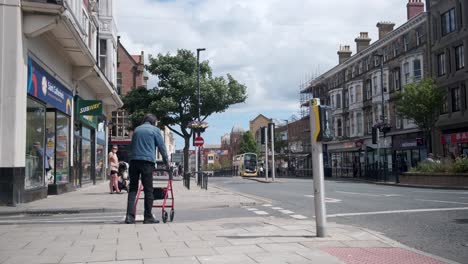 footage-of-Scarborough-town-centre,-with-a-man-walking-with-a-walking-frame