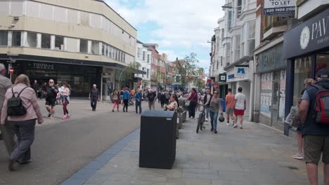 footage-of-Scarborough-town-centre,-North-Yorkshire-on-a-summer-day-on-a-busy-weekend-with-families-and-couples-walking-around-the-shops-in-the-town