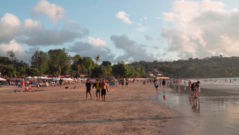 Gente-Nadando-En-La-Playa-De-Jimbaran-Al-Atardecer-En-Bali,-Indonesia