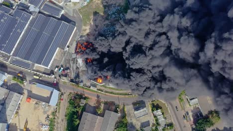 Humo-Negro-Espeso-Y-Peligroso-De-Una-Fábrica-En-Llamas,-Drones-En-órbita-Desde-Arriba