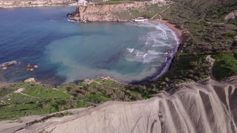 Drone-video-of-waves-crashing-against-the-shore-with-forests-and-cliffs-visible