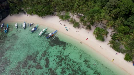 Vídeo-De-Dron-En-4k-De-Personas-Disfrutando-De-La-Playa-Papaya,-Una-Playa-Tropical-De-Arena-Blanca-En-Palawan,-Filipinas