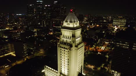 Eine-Beeindruckende-Luftaufnahme-Des-Rathauses-Von-Los-Angeles-Bei-Nacht,-Die-Die-Wunderschön-Beleuchtete-Architektur-Und-Das-Lebendige-Stadtbild-Der-Innenstadt-Von-LA-Einfängt