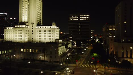 Eine-Atemberaubende-Luftaufnahme-Des-Rathauses-Von-Los-Angeles,-Wunderschön-Beleuchtet-Bei-Nacht,-Zeigt-Die-Architektonische-Eleganz-Und-Das-Pulsierende-Nachtleben-Der-Stadt