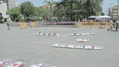 General-shot-of-several-firecrackers-after-exploding-with-sand-bags-around-them-in-a-Valencian-masclet?