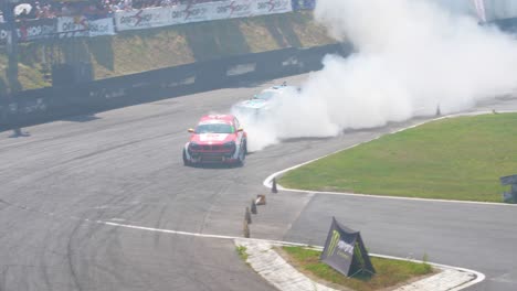 two-race-cars-drifting-on-a-very-tight-curve-with-lots-of-smoke