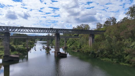 Aerial-flies-close-up-to-rail-and-road-bridges-spanning-the-Pioneer-River-by-Mirani-township