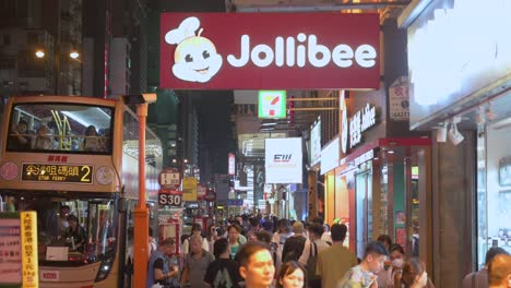 Los-Peatones-Pasan-Por-La-Cadena-Multinacional-Filipina-De-Comida-Rápida-Restaurante-Jollibee-Durante-La-Noche-En-Hong-Kong