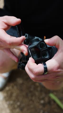 Vertical-high-angle-view-of-person-remove-protection-glass-from-drone-lens