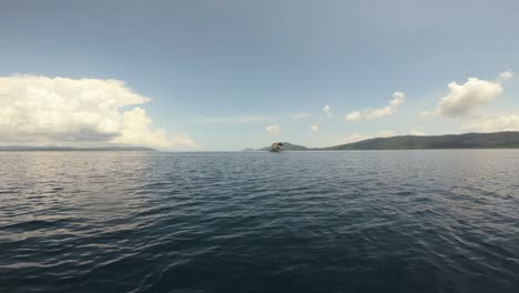 A-view-from-a-moving-boat-captures-the-vast-expanse-of-the-ocean-in-Raja-Ampat,-Indonesia