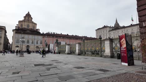 View-of-Piazza-Castello-in-Turin,-Italy,-with-people-walking-through-the-square,-capturing-the-lively-atmosphere-and-cultural-essence-of-this-historic-city-center