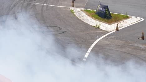 Coches-De-Carreras-Rojos-Y-Grises-A-La-Deriva-En-Una-Curva-Muy-Cerrada-Con-Mucho-Humo.