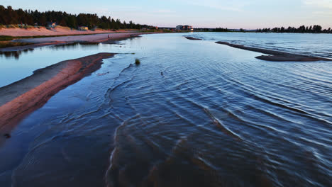 Aerial-view-backwards-over-sandbanks-in-calm-waters-of-Kalajoki,-summer-in-Finland