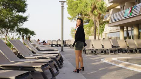 Female-tourist-walk-near-Cala-Vinyes-Beach-hotel-deck-chair-line,-Mallorca