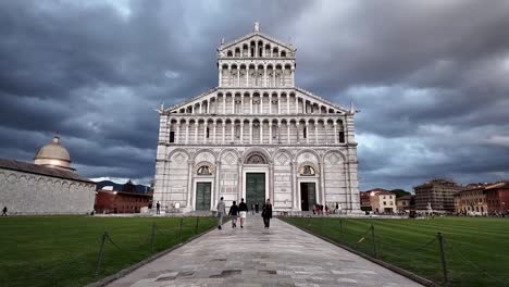 Visitantes-Caminando-Frente-A-La-Catedral-De-Pisa-En-Pisa,-Italia,-En-Un-Día-Nublado,-Mostrando-La-Belleza-Arquitectónica-Y-El-Significado-Histórico-De-Este-Emblemático-Monumento.