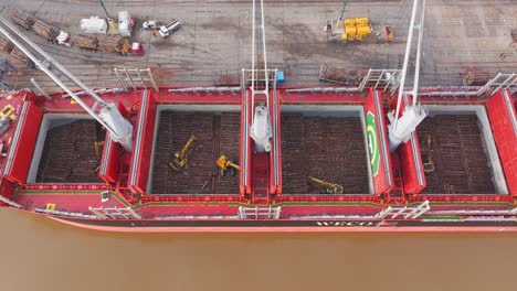 Cargo-ship-Weco-Laura-along-Uruguay-river-loading-logs-with-cranes-and-excavators