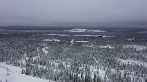 AERIAL:-Polar-landscape-of-hills,-forest-and-Lapland-wilderness,-gloomy-winter-day