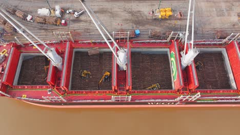 Cargo-ship-Weco-Laura-along-Uruguay-river-loading-logs-with-cranes-and-excavators